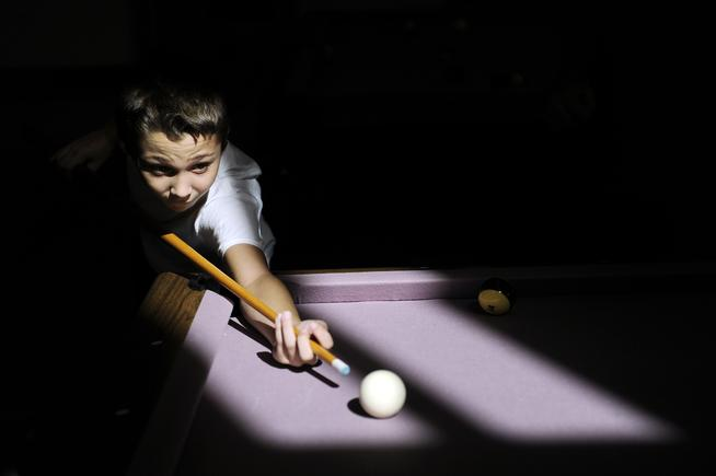 Tristen Rose, 11, lines up a shot as he plays pool at Suncor Boys &amp; Girls Club in Commerce City on Aug. 27.